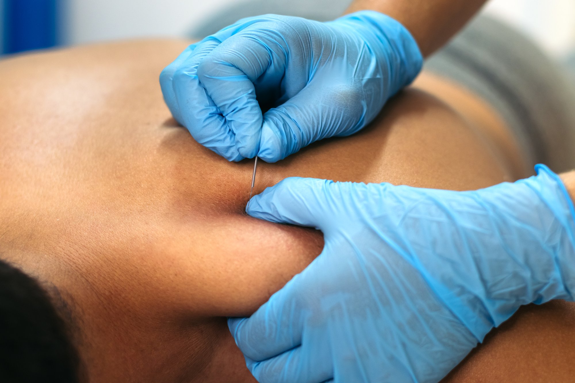Physical therapist applying manual therapy to patient's lower back for lasting pain relief in San Antonio